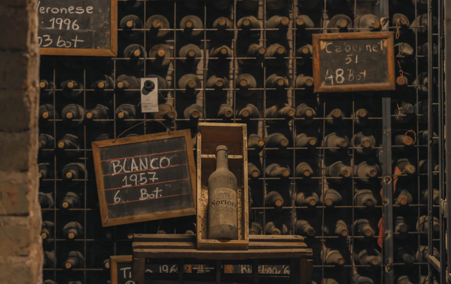 Hand-chalked vintage boards above a winery cellar rack