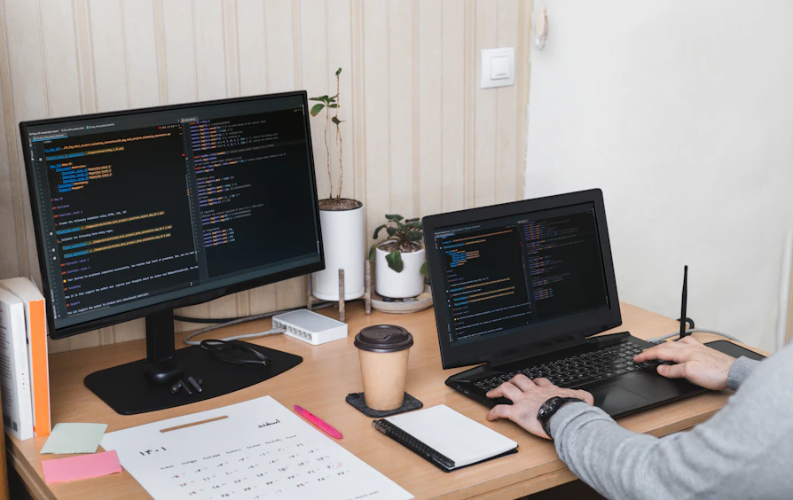 Developer working across two screens of code